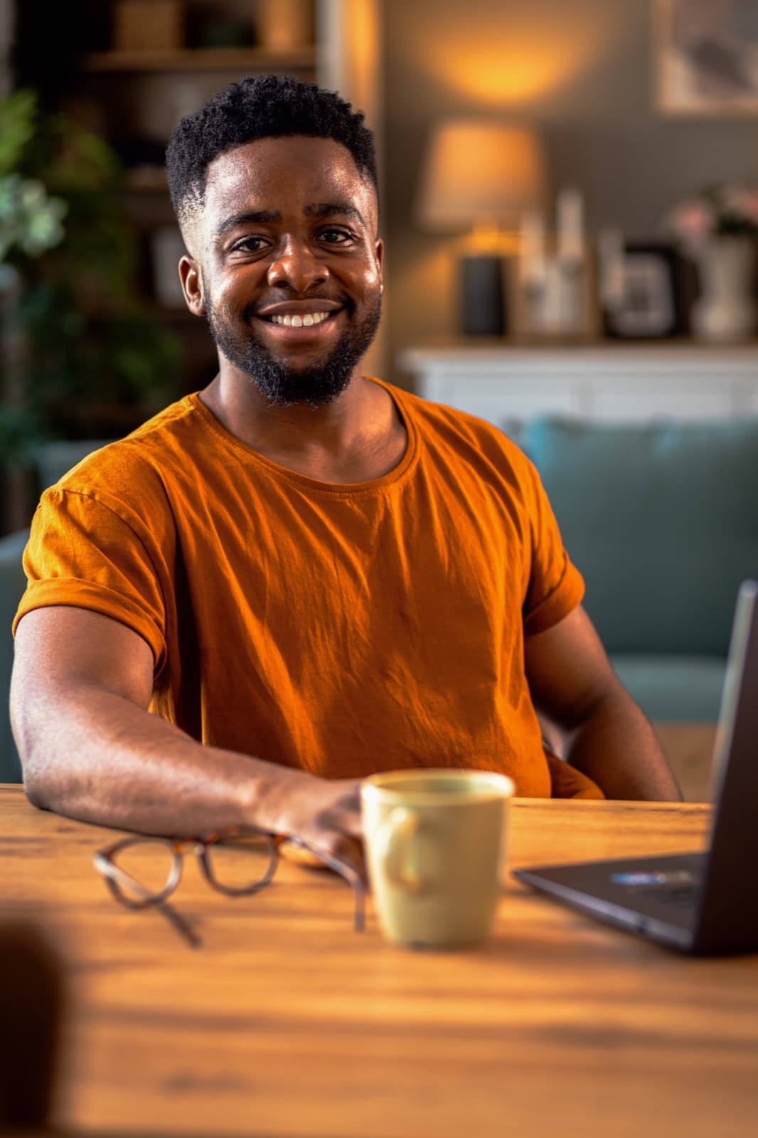A freelancer working on his laptop with a coffee at his desk